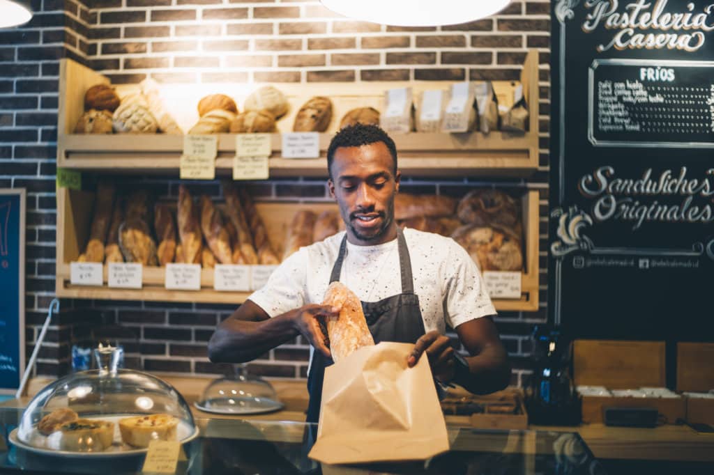 Black man sells in bakery.