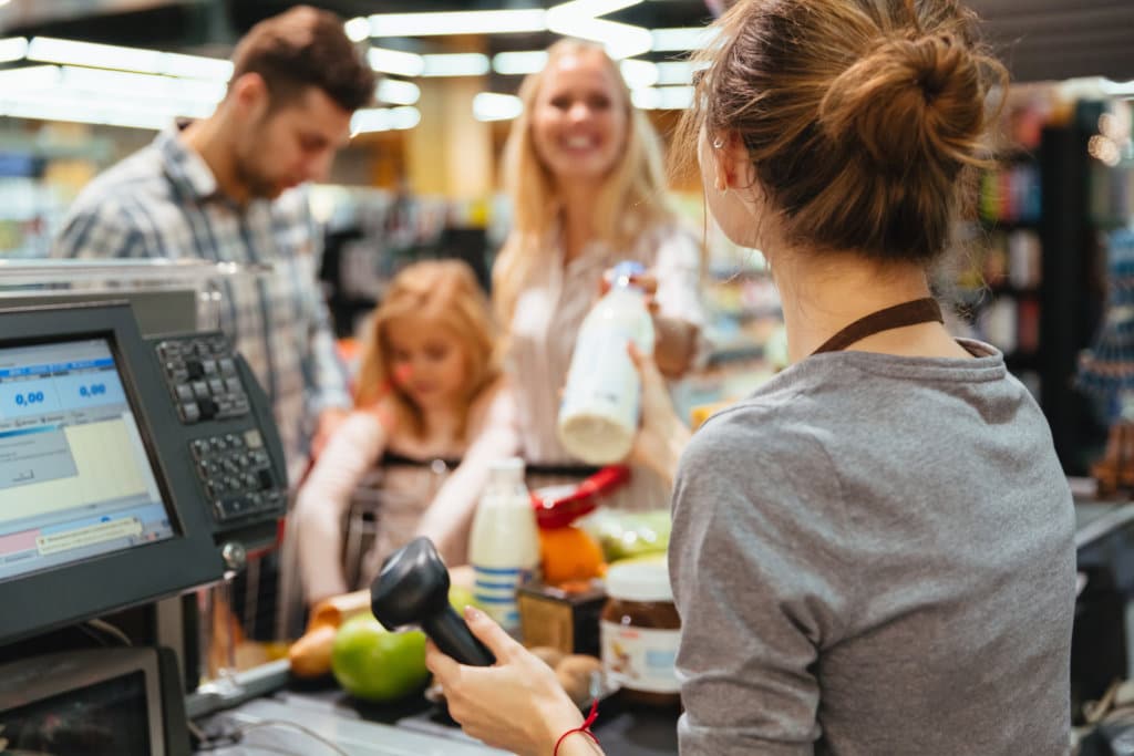 Cheerful family standing at the cash counter